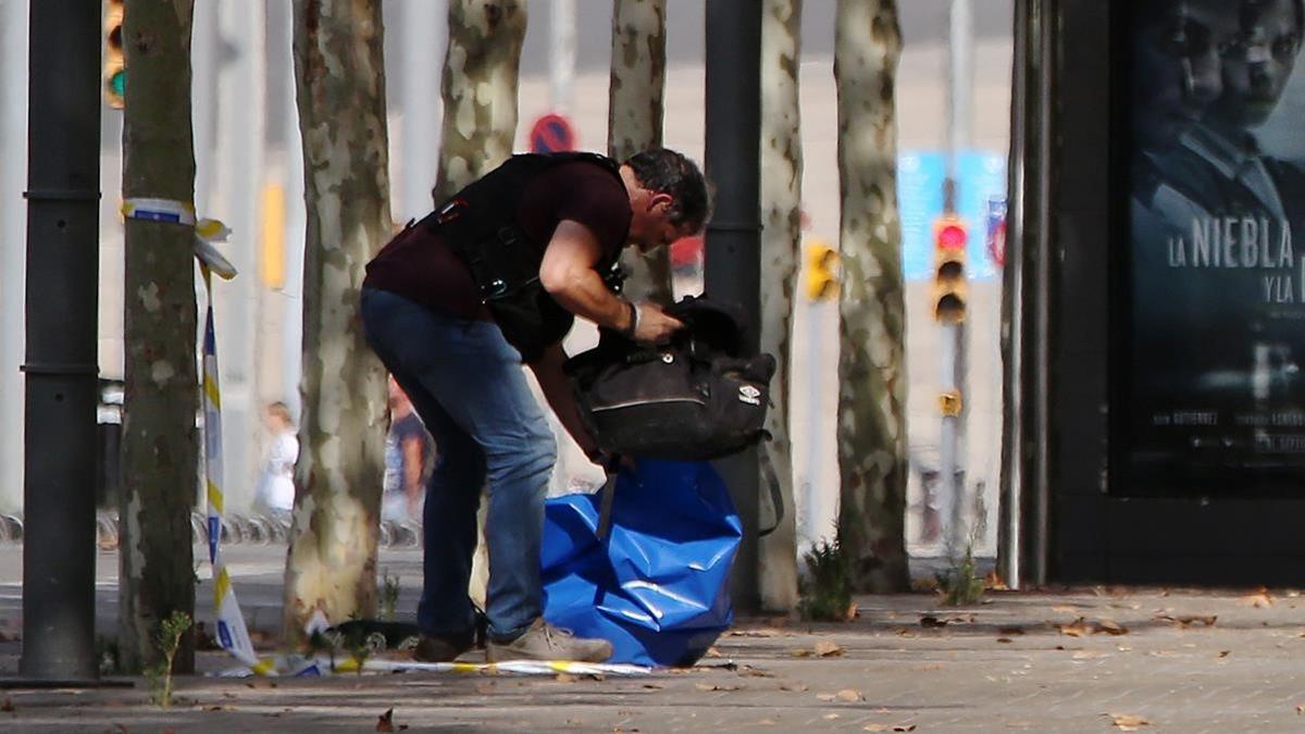 Un agente de los Tedax inspeccionando la mochila abandonada.