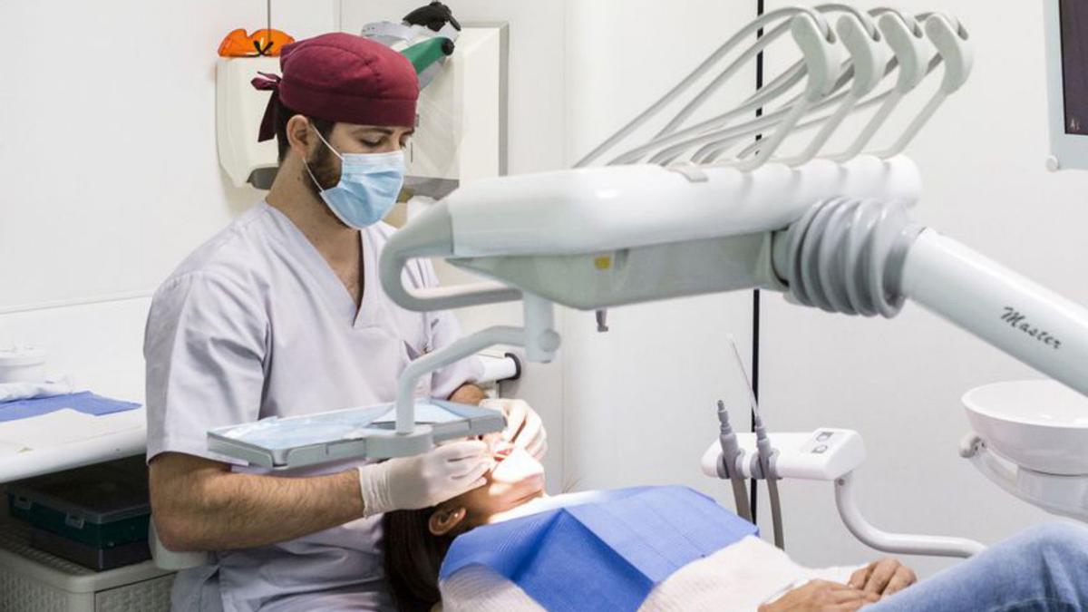 Un dentista atiende a una paciente en su consulta.