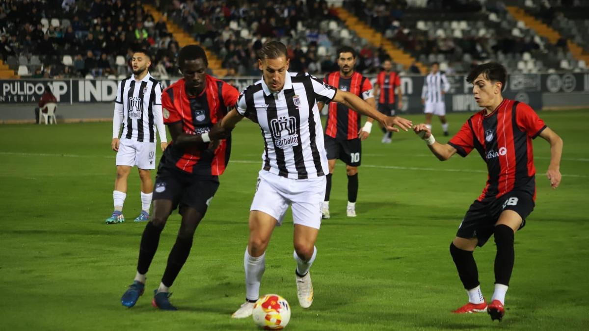 Álex Alegría, entre dos rivales en un partido de esta temporada en el Badajoz.