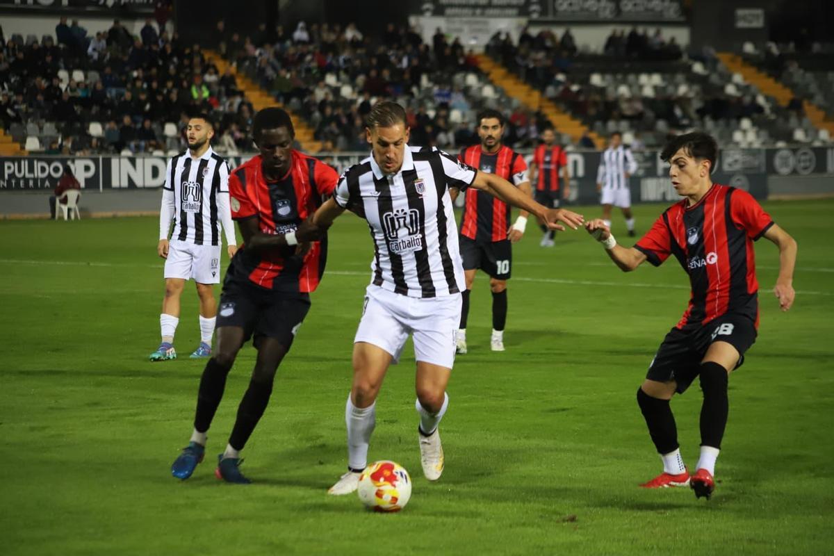Álex Alegría, entre dos rivales en un partido de esta temporada en el Badajoz.