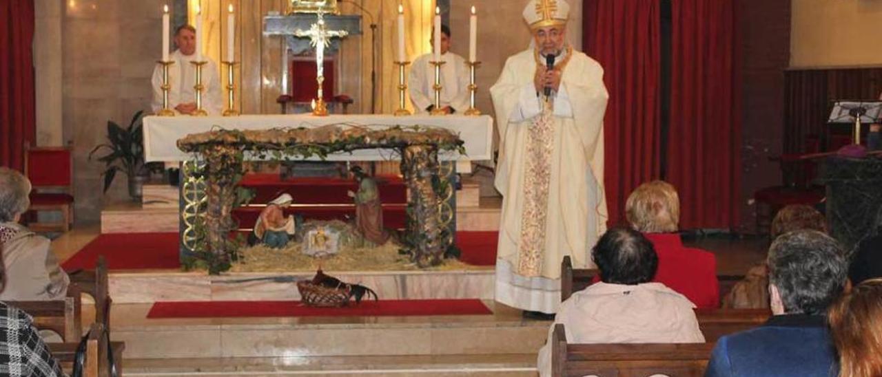 Jesús Sanz, dirigiéndose a los feligreses junto al gallo, durante la misa de Nochebuena, en Lugones.