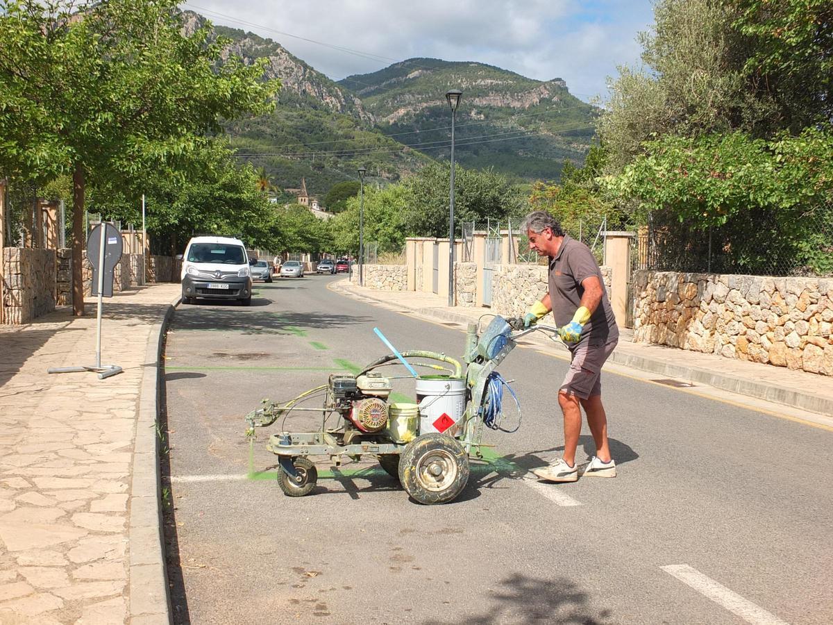 Un operario pinta de color verde las plazas delimitadas para los residentes de Sóller.