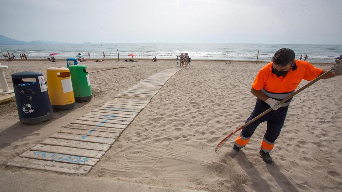Un operario limpia una playa de Alicante, en una imagen de archivo.