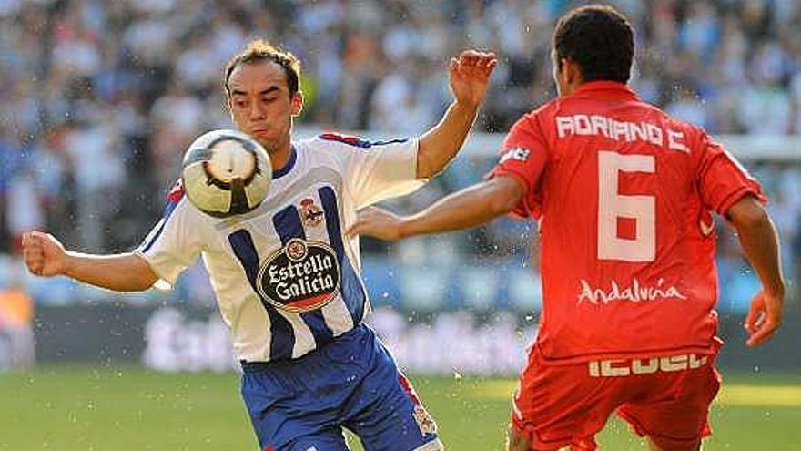 Iván Pérez controla el balón ante el sevillista Adriano. / carlos pardellas