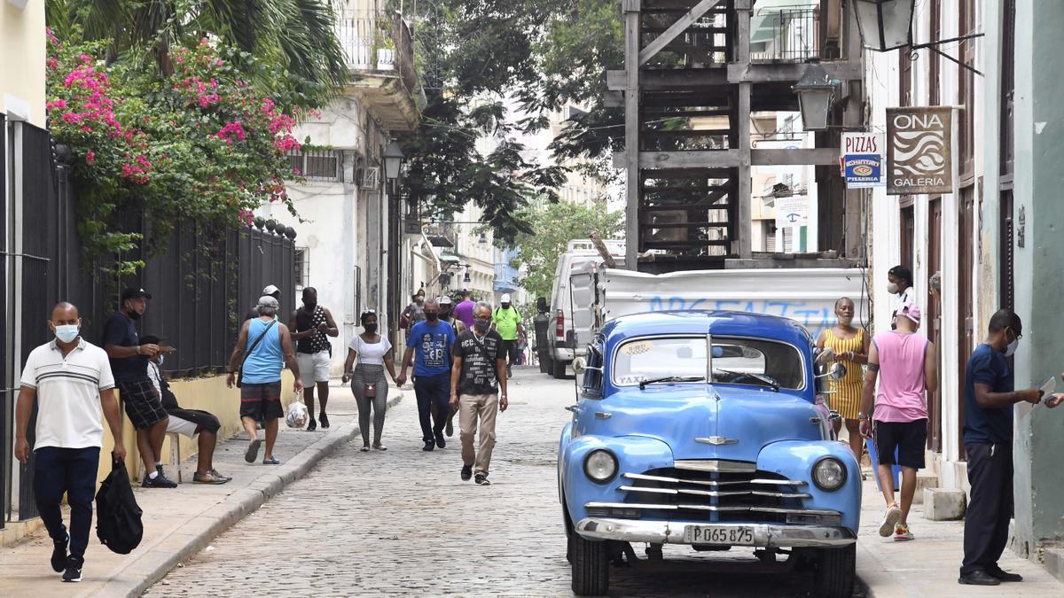 Personas con mascarilla en una calle de La Habana.