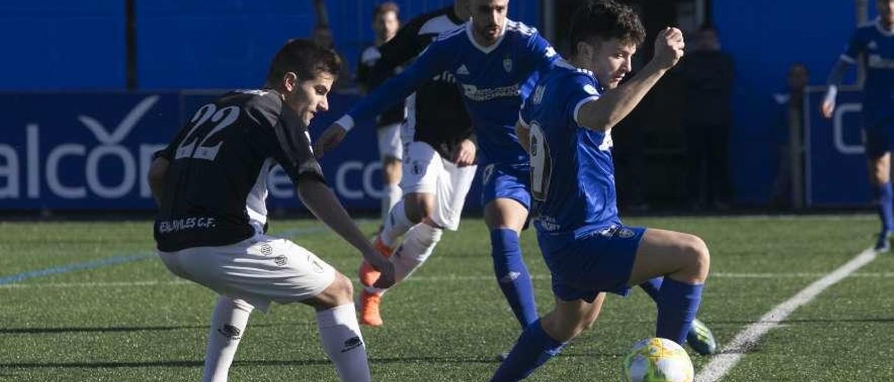 El jugador del Covadonga Simón, con el balón, presionado por Pereira, del Avilés.