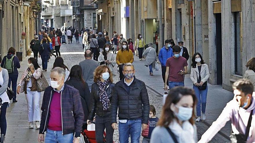 Gent passejant pel centre de Girona durant el confinament perimetral pel coronavirus