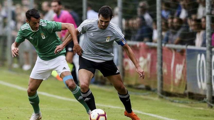 Tejera, del Oviedo, y Lucas, del filial, en el primer partido de la pretemporada Oviedo-Vetusta en El Requexón.