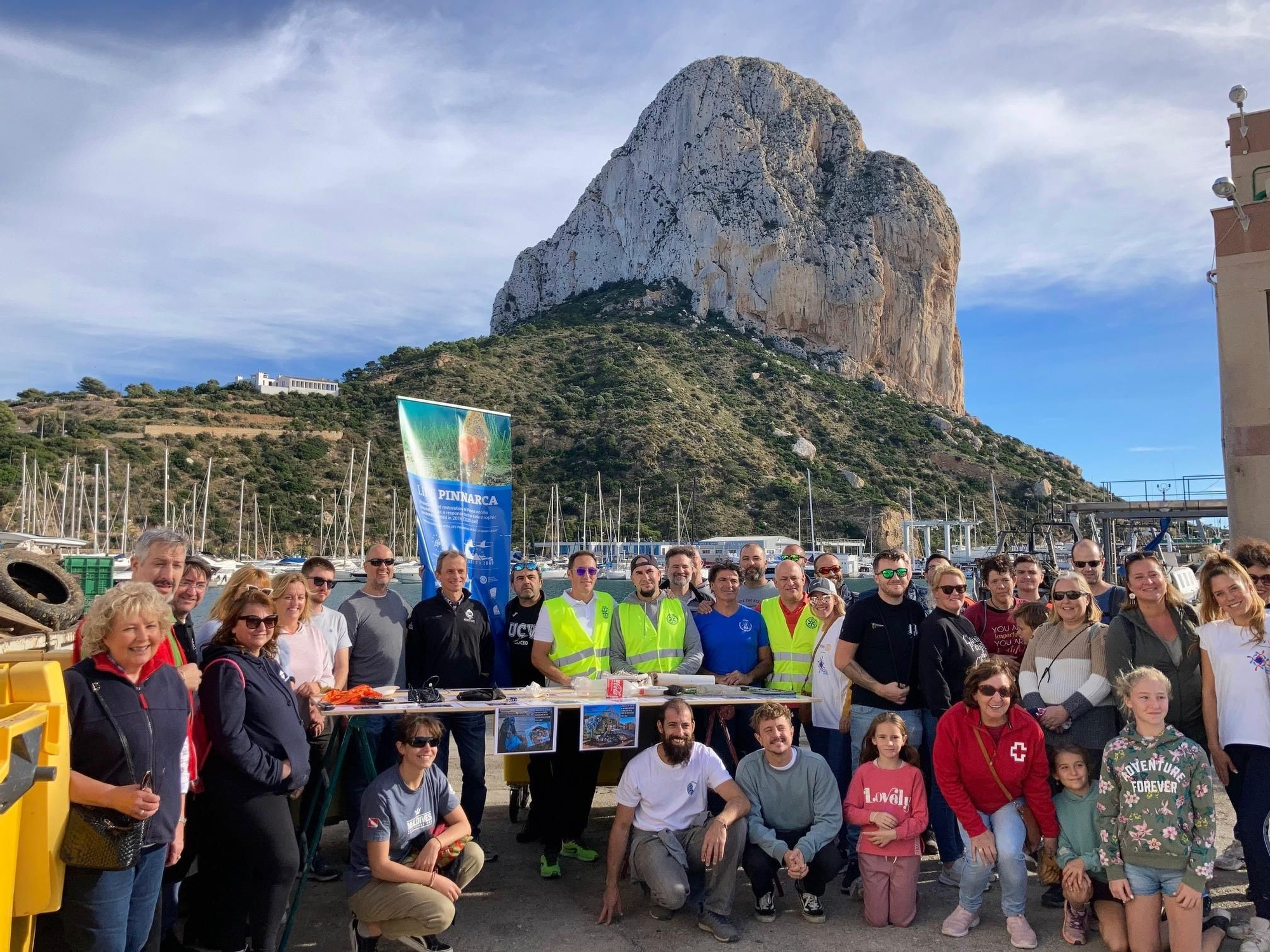 Diversos voluntarios con el Penyal d&#039;Ifac al fondo