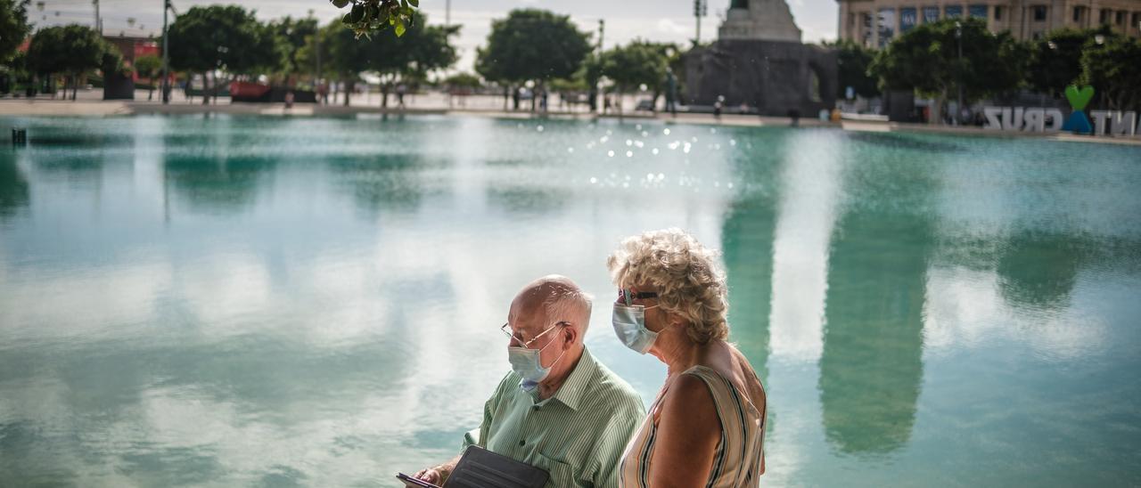 Una pareja con mascarilla en la Plaza de España, en Santa Cruz de Tenerife.