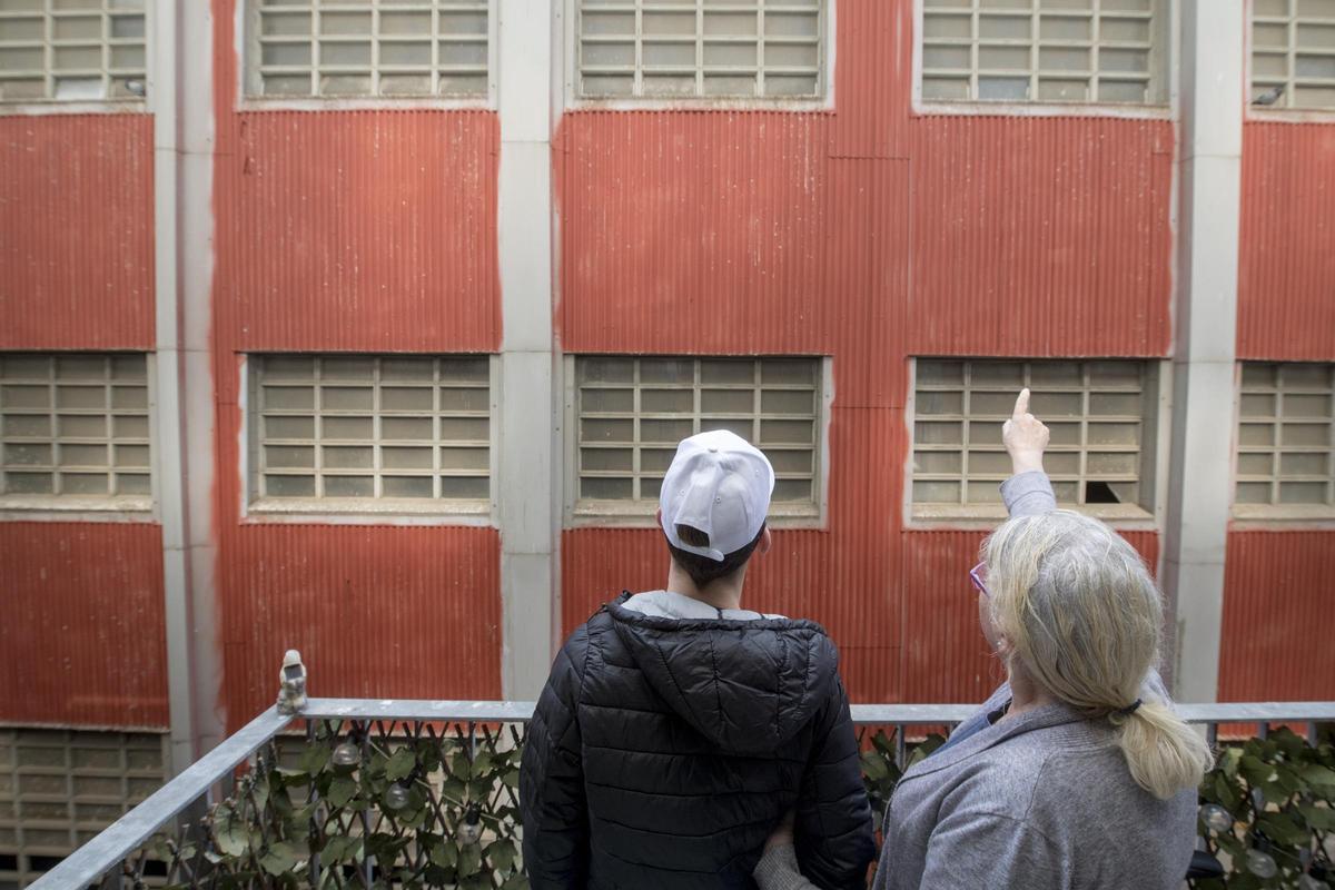 Dos vecinos de Barcelona observan una pared con amianto, delante de un piso próximo al 22@.