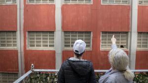 Dos vecinos de Barcelona observan una pared con amianto, delante de un piso próximo al 22@.