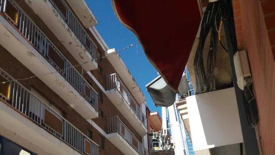 Los bomberos retirando las partes con riesgo de caer al vacío en el edifico de Nuevo Import en Herreros