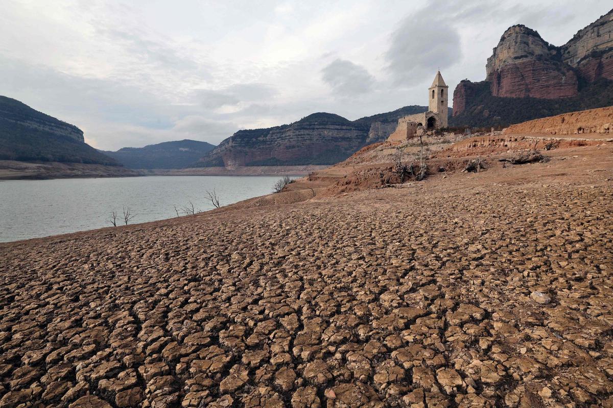 Esta fotografía tomada el 15 de enero de 2024 muestra la iglesia de Sant Roma de Sau en la orilla del estiaje del embalse de Sau, situado en la provincia de Girona en Cataluña. Cataluña lucha contra una sequía histórica desde hace tres años y algunos residentes ya experimentan restricciones de agua en su vida diaria.