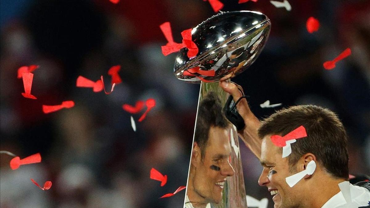 TAMPA  FLORIDA - FEBRUARY 07  Tom Brady  12 of the Tampa Bay Buccaneers celebrates as he is reflected in the Lombardi Trophy after defeating the Kansas City Chiefs in Super Bowl LV at Raymond James Stadium on February 07  2021 in Tampa  Florida  The Buccaneers defeated the Chiefs  31-9    Patrick Smith Getty Images AFP (Photo by Patrick Smith   GETTY IMAGES NORTH AMERICA   AFP)