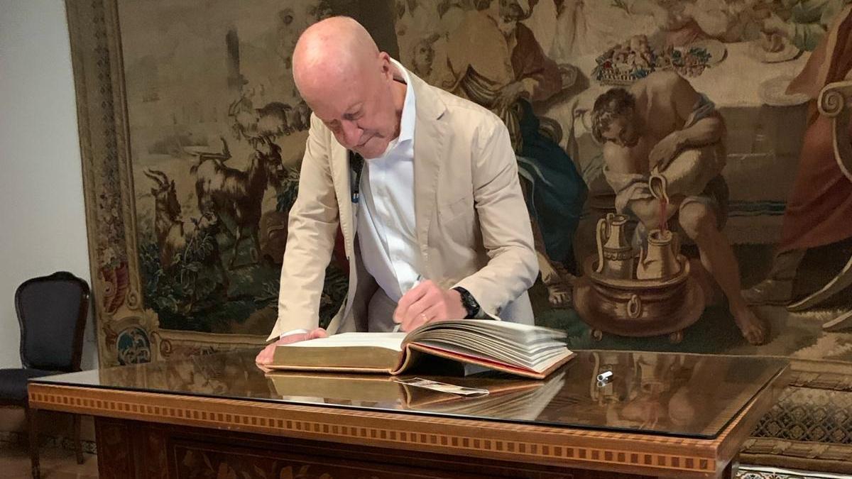 El arquitecto Norman Foster firma en el libro de visitas del Palacio de Viana.