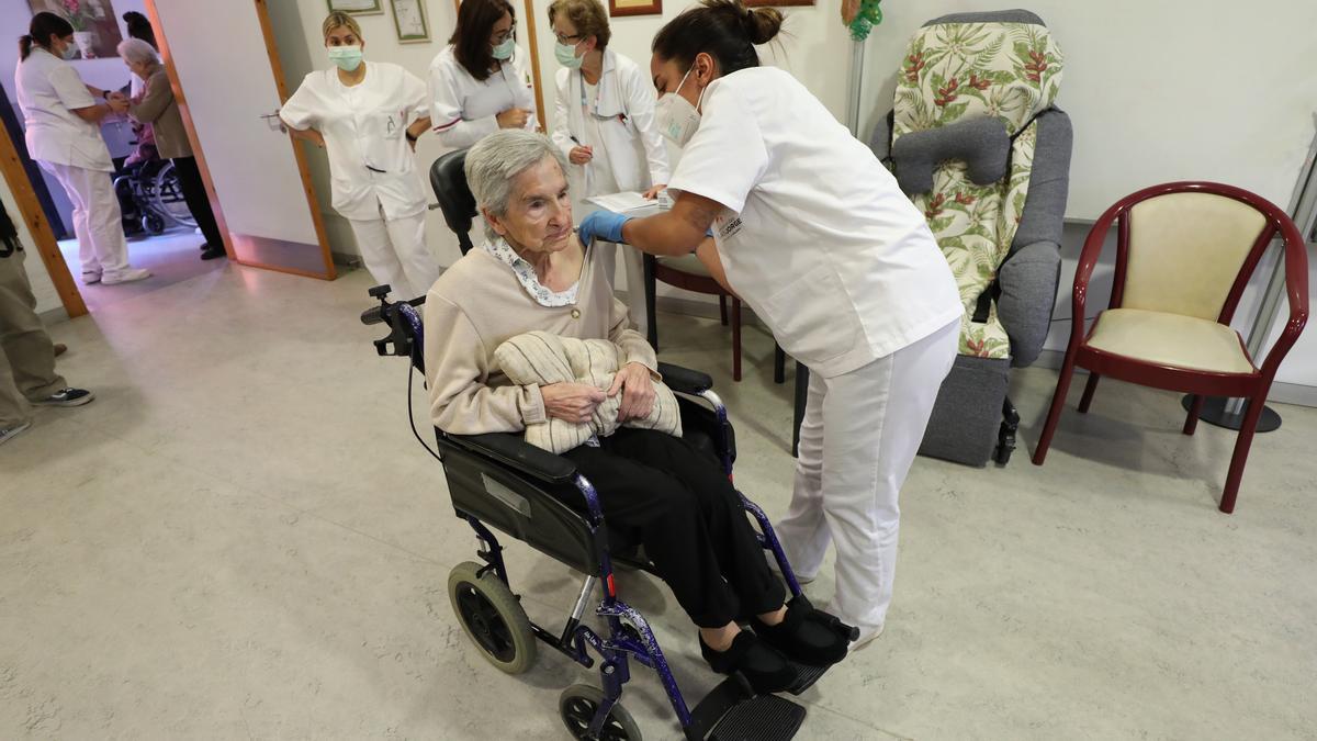 Una sanitaria vacuna a una mujer en la residencia San Eugenio, ayer en Zaragoza.