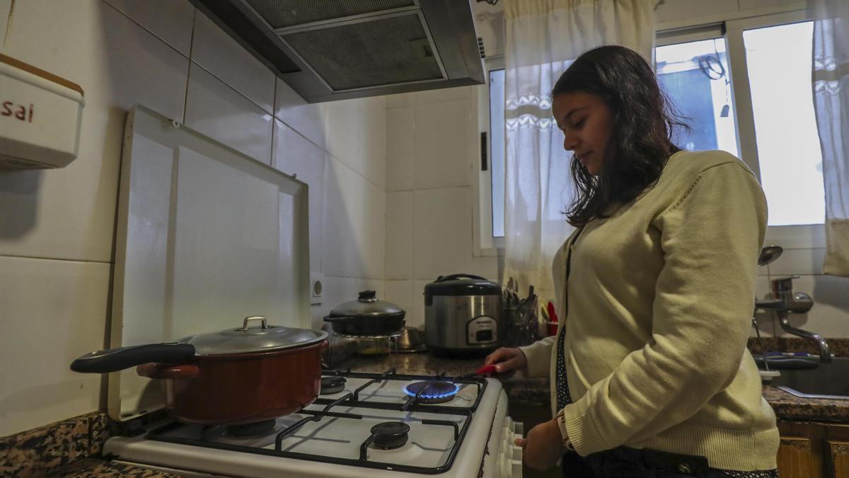 Una mujer migrante cocinando en su casa, en una fotografía de archivo