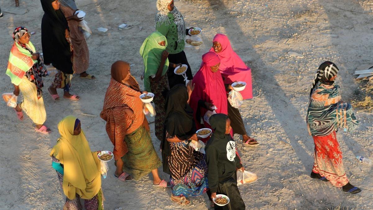 Unos inmigrantes caminan tras recibir comida en un centro de detención en Sabratha, el pasado 9 de octubre.