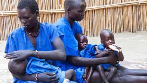 Dos mujeres cuidan a sus hijos malnutridos en un centro de estabilización de Sudán del Sur.