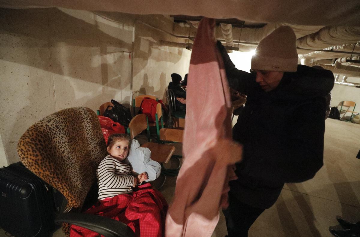 Ciudadanos de Kiev se refugian en el sótano de una escuela en la ciudad, a modo de refugio ante los ataques rusos.