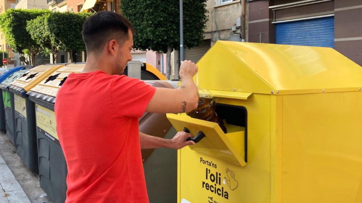 Un vecino de Viladecans recicla aceite en un contenedor.