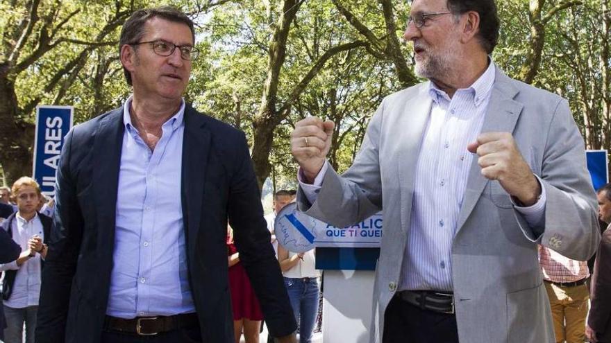 Feijóo, a la izquierda, y Rajoy conversan en el acto de su formación, ayer.