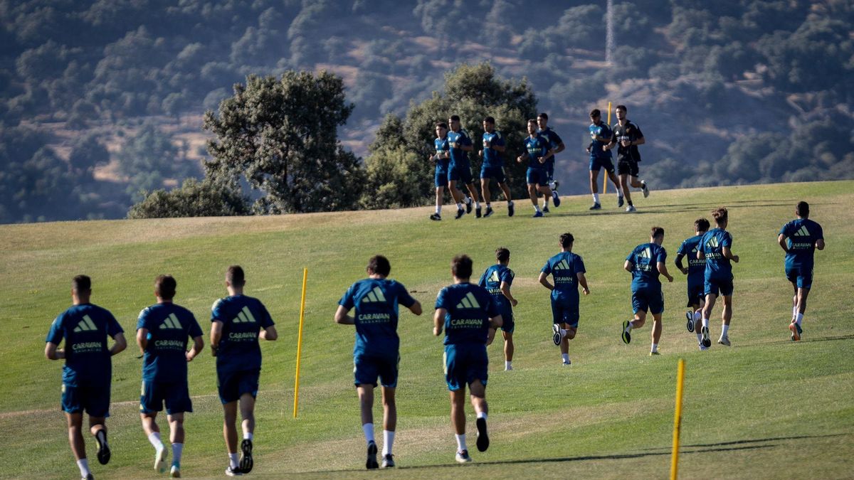 La plantilla zaragocista, por grupos, corre en el campo de gol.