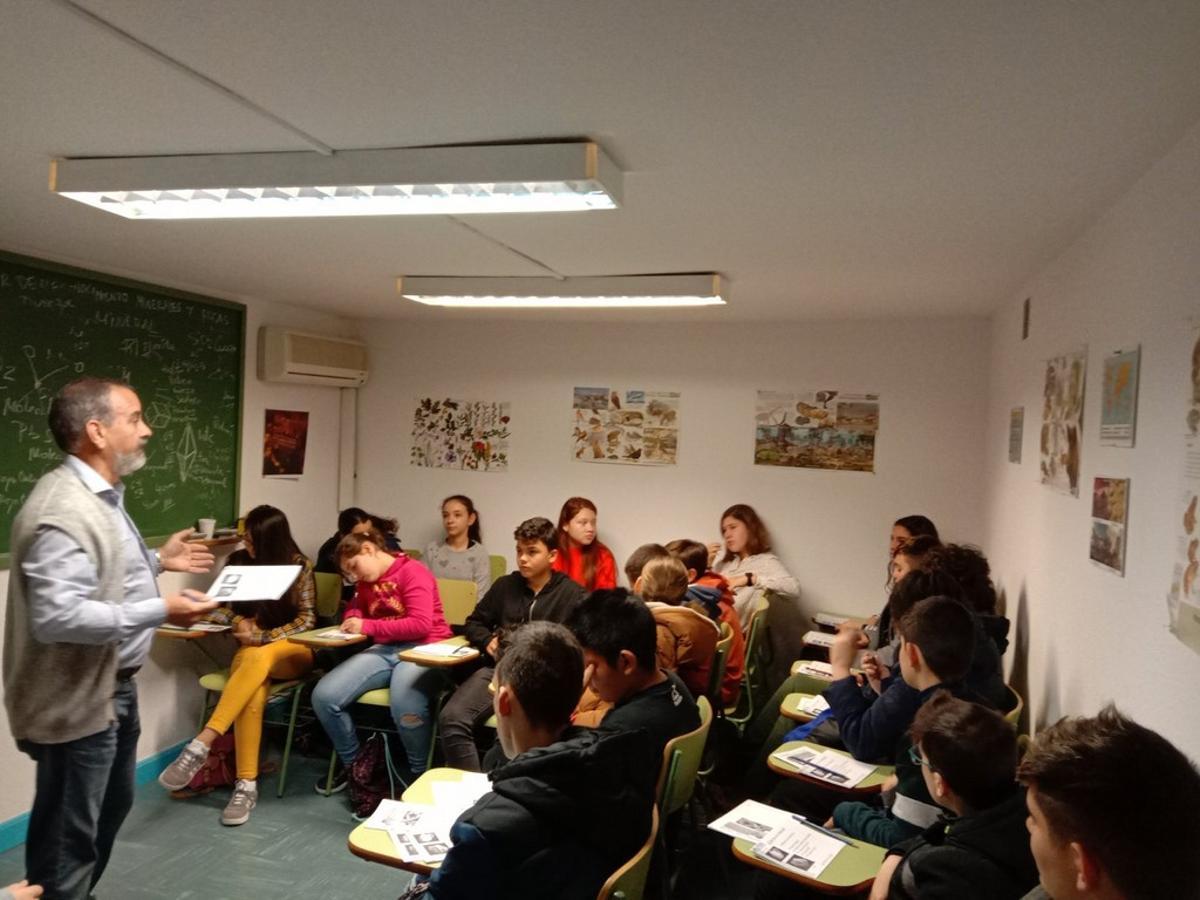 El director del aula museo, con un colegio en el taller de rocas y minerales.