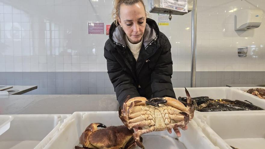 Tania, encargada del puesto de OCP en la plaza de Vilagarcía, muestra un ejemplar de más de dos kilos, ayer.