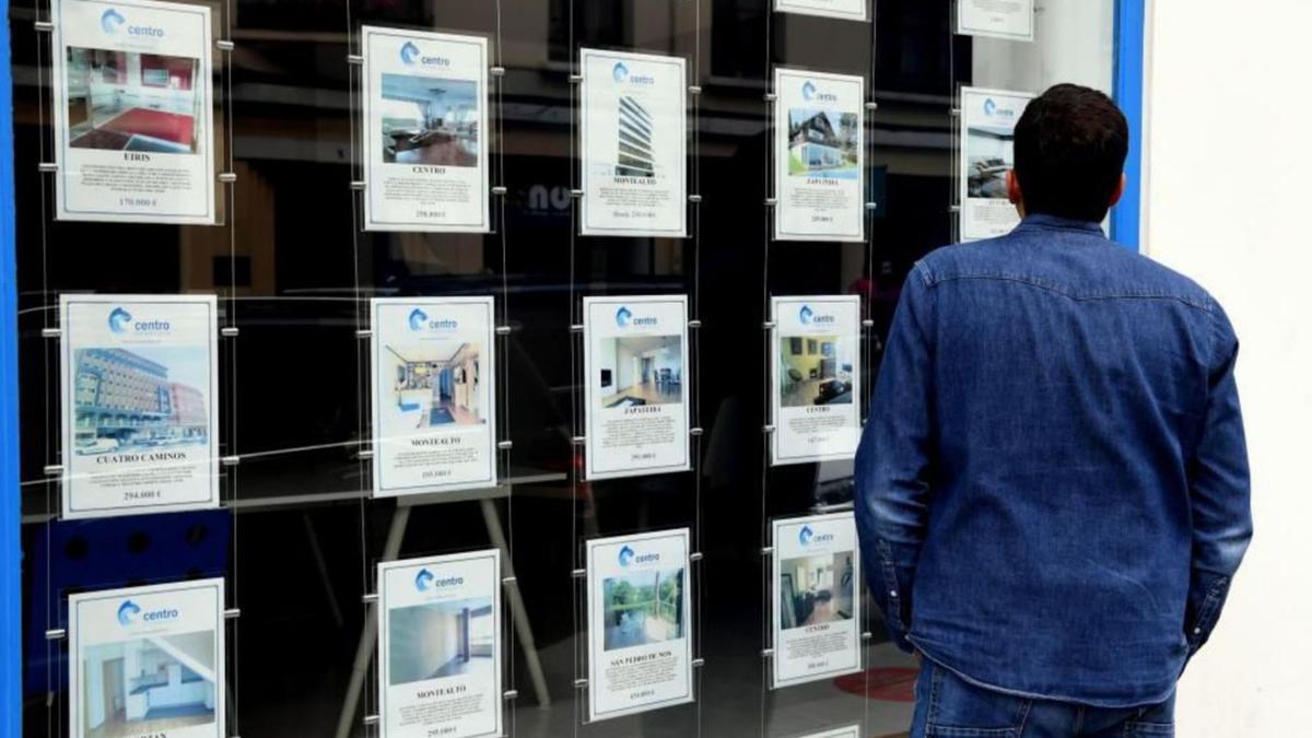 Un hombre observa las ofertas de viviendas en una agencia inmobiliaria.