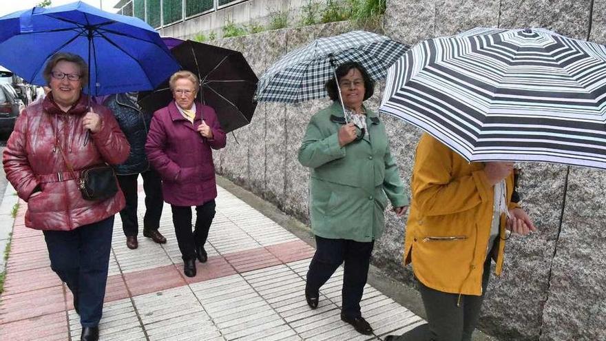 Un grupo de señoras, ayer, se protege de la lluvia caída en A Coruña.
