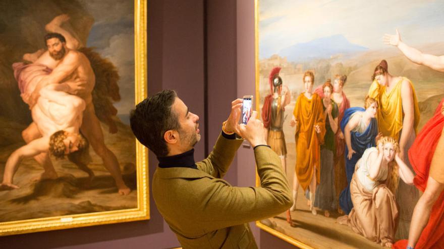Un joven fotografía uno de las obras de Tegeo expuestas en el Museo del Romanticismo.