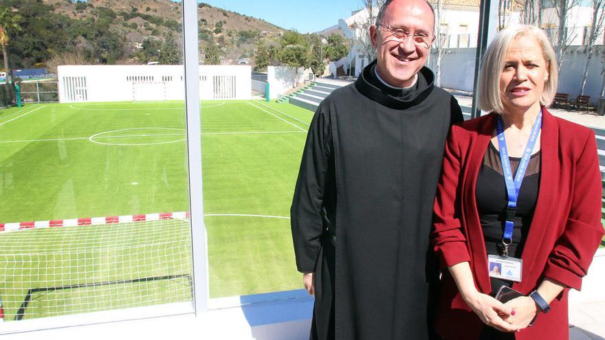 El hermano Luis Valero y una de las responsables del centro, delante del nuevo campo de fútbol.