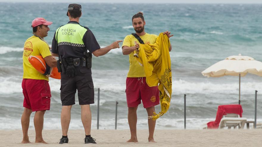 Socorristas cambiando la bandera junto a la Policía en la playa de San Juan