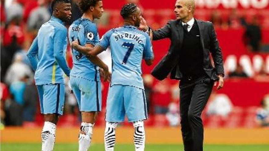 Pep Guardiola felicita tres dels seus jugadors després de la victòria del City a Old Trafford (1-2).