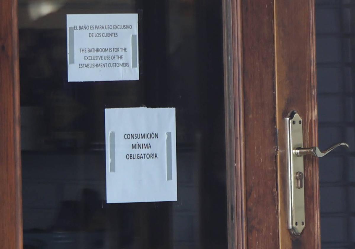 Cartel advirtiendo de consumición mínima en una cafetería de Vigo.