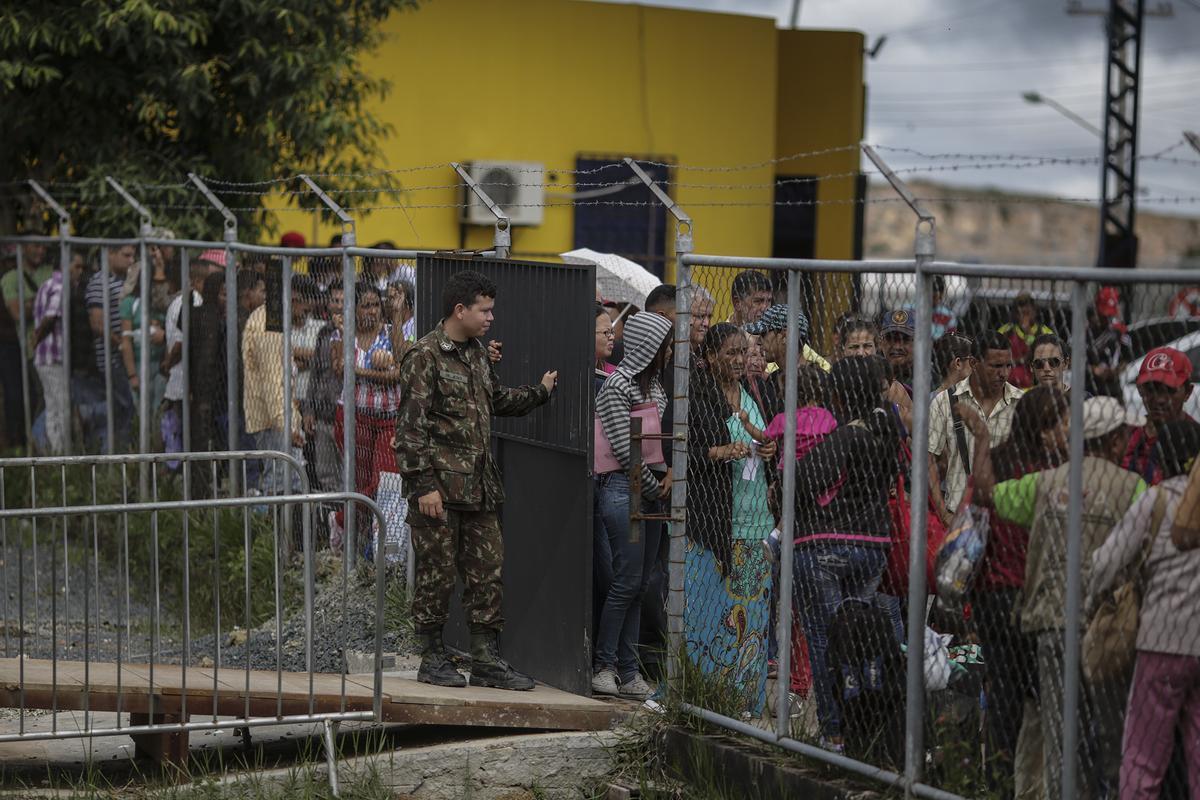 Centenas de inmigrantes venezolanos esperan para obtener autorización para ingresar a Brasil, en la sede de la aduana brasileña, en la Policía Federal de Pacaraima (Brasil) en 2018.