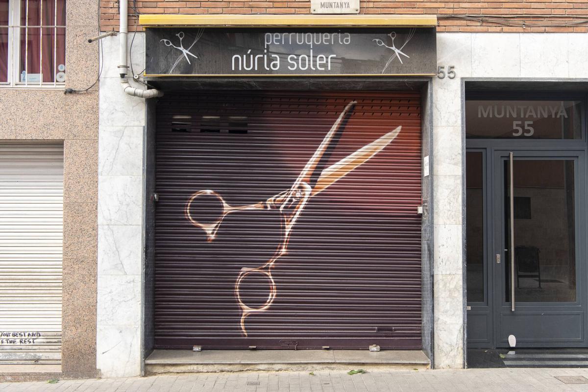 Persiana de la peluquería Núria Soler, en la calle Muntanya, 55, pintada por el artista Roc Blackblock. Barcelona, 11 de agosto de 2026. Foto: Belén González / EP
