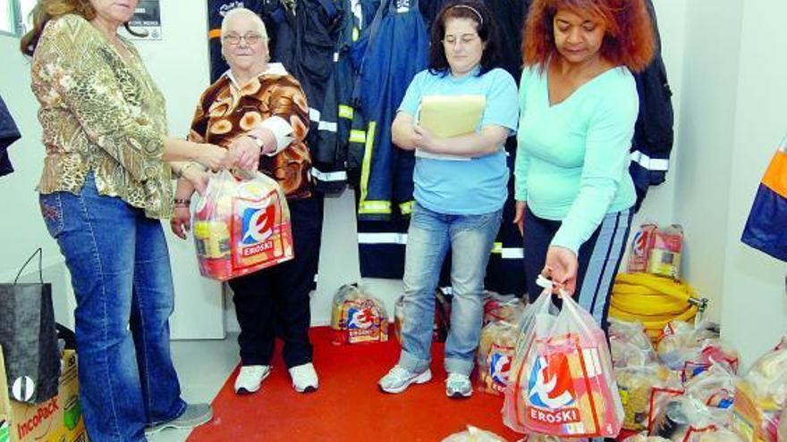 Varias inmigrantes, ayer, durante el reparto de alimentos.