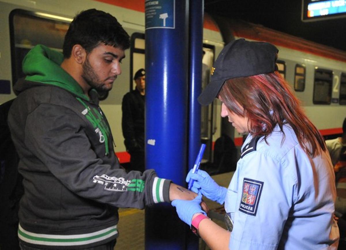 La policía checa marca con números a los refugiados