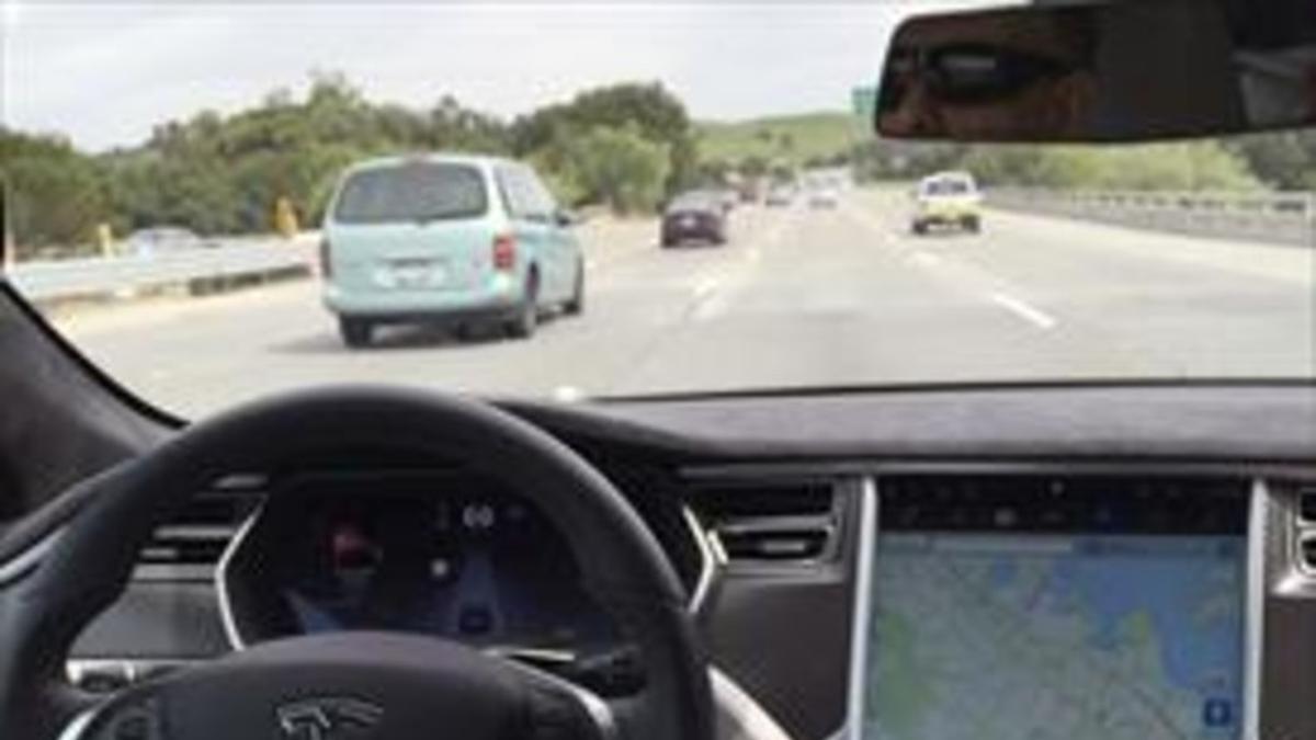 Un coche de Tesla con el piloto automático de conducción autónoma activado.