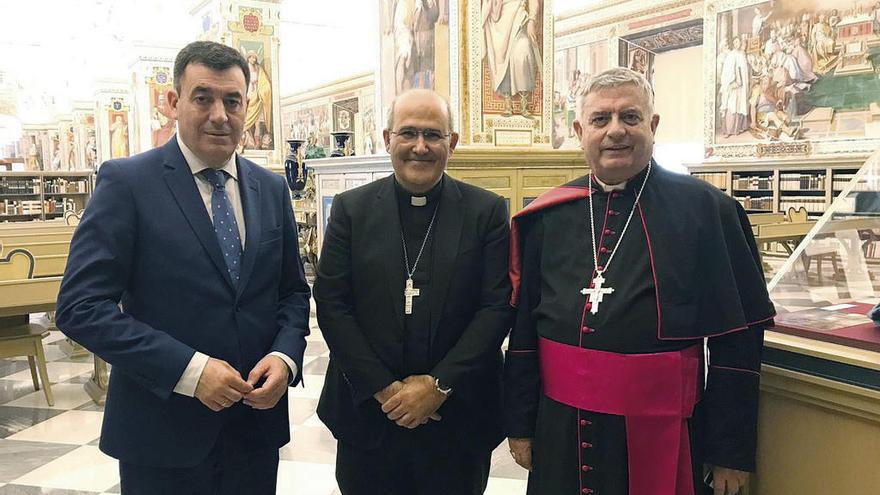 El conselleiro de Cultura, Román Rodríguez, con el secretario de la Congregación para los Institutos de Vida Consagrada y las Soc. de Vida Apostólica, José Rodríguez Carballo, y el archivista de la Biblioteca Vaticana, José Tolentino. A la izq., un extracto de la cantiga del Cancionero de la Vaticana.