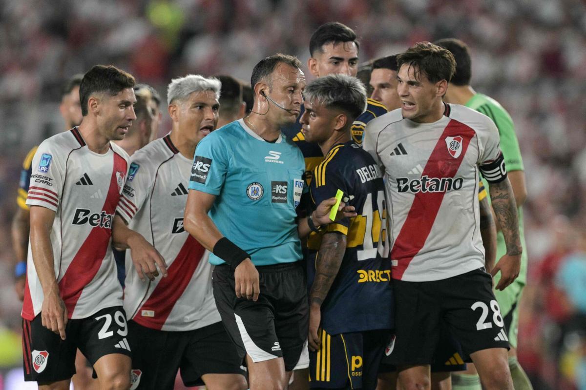 River Plate's defender #29 Gonzalo Montiel, forward #07 Maximiliano Salas, and defender #28 Lucas Martinez Quarta argue with Argentine referee Dario Herrera during the Argentine Professional Football League 2026 Apertura Tournament match between River Plate and Boca Juniors at MAS Monumental stadium in Buenos Aires on April 19, 2026. (Photo by JUAN MABROMATA / AFP)