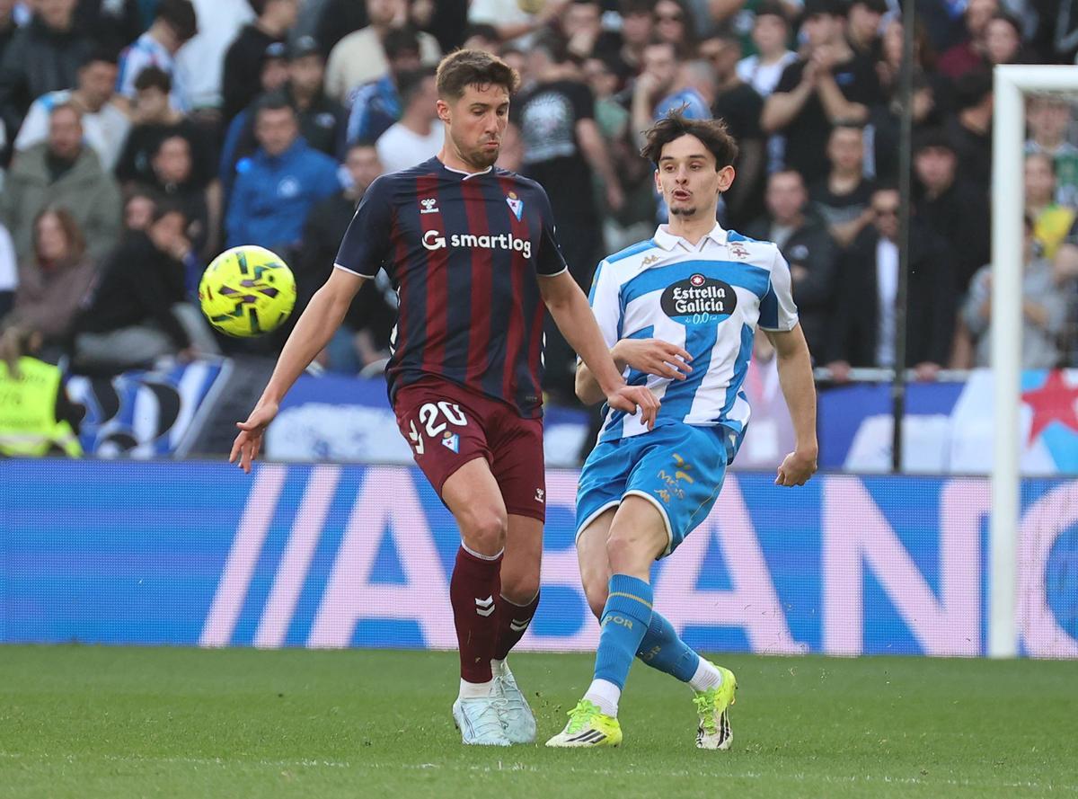 Charlie Patiño da un pase ante un jugador del Eibar en Riazor.