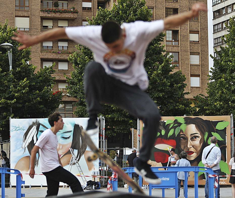 Skaters patinando en La Exposición, con un fondo de grafitis.