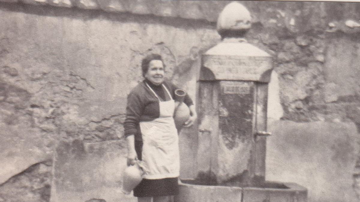Una vecina llena sus cántaros de agua en la fuente de la plaza de la Sangre de l'Alcora, en una foto de archivo.