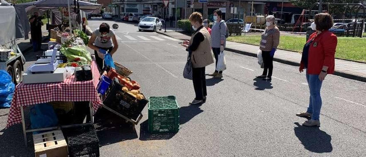 Clientes esperando para comprar en uno de los puestos del mercadillo de El Berrón.