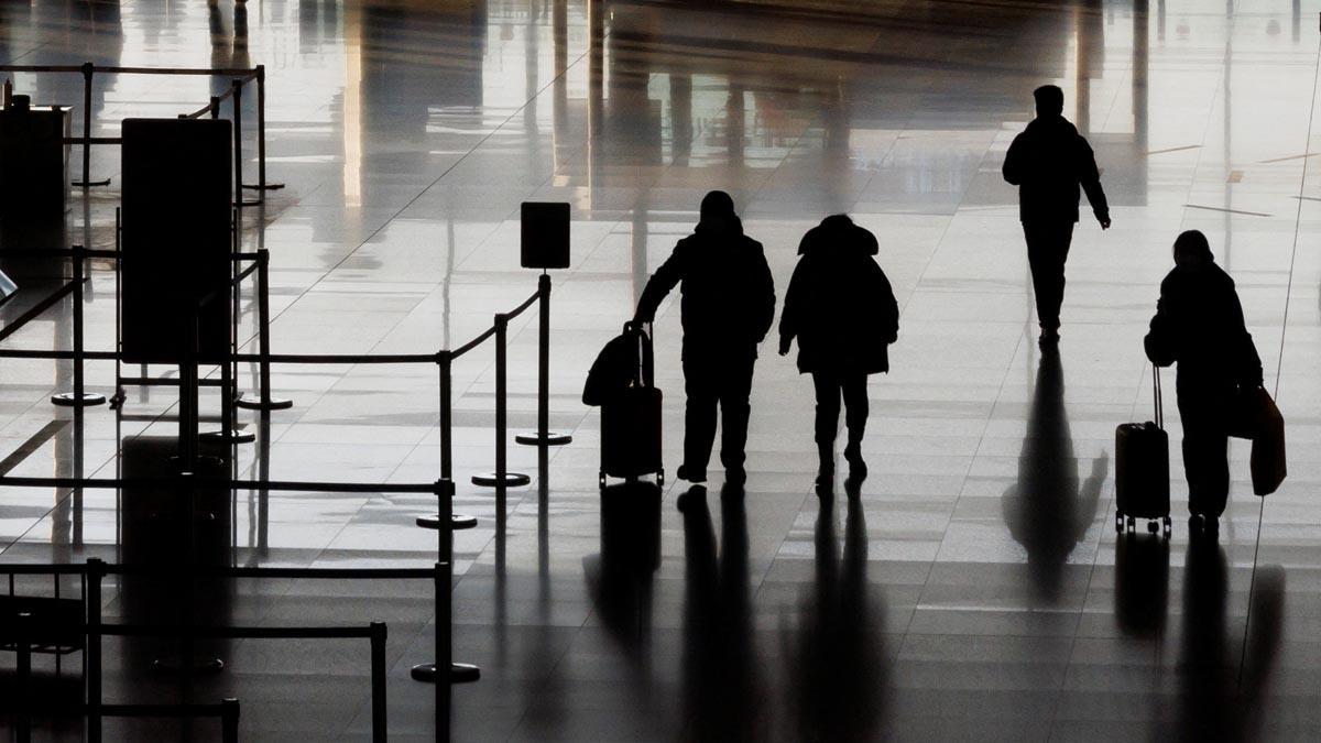 Gente caminando por la sala de salidas del Aeropuerto Internacional Capital de Beijing después de que China levantara el requisito de cuarentena.