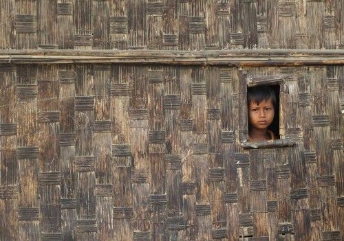 A boy looks from his temporary shelter at a Rohingya refugee camp as Myanmar's government embarks on a national census, in Sittwe